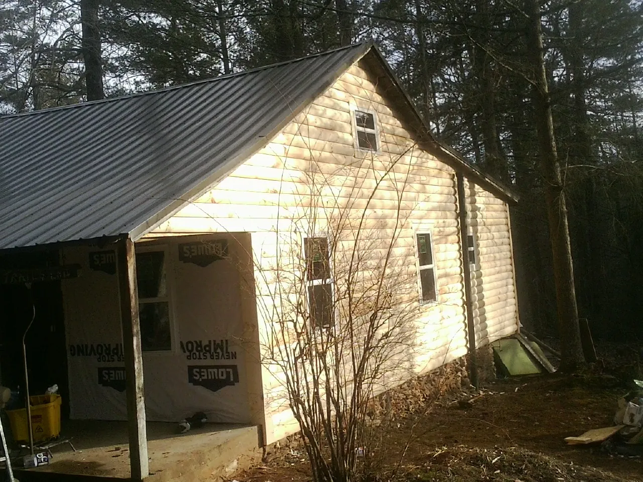 Log siding gable end under a dark metal roof edge in Southport