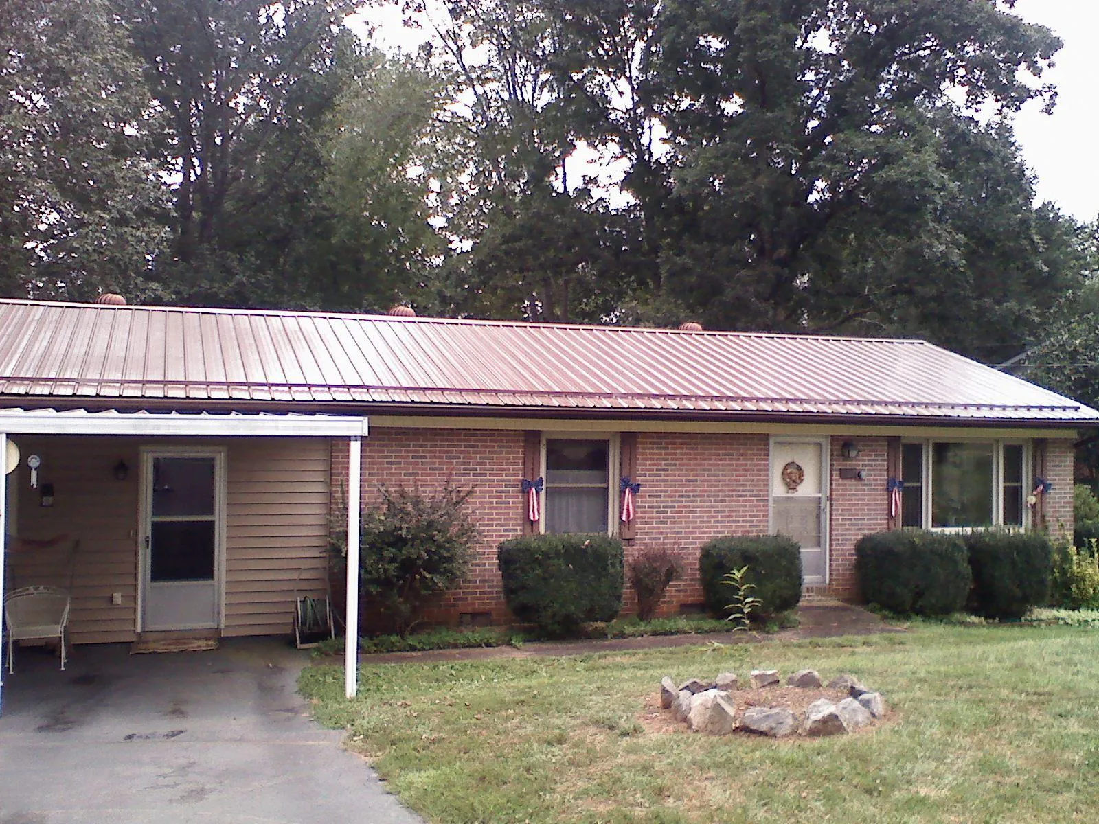 Bronze metal roof and carport on a brick ranch home — Roof Repair work by our crew in Southport